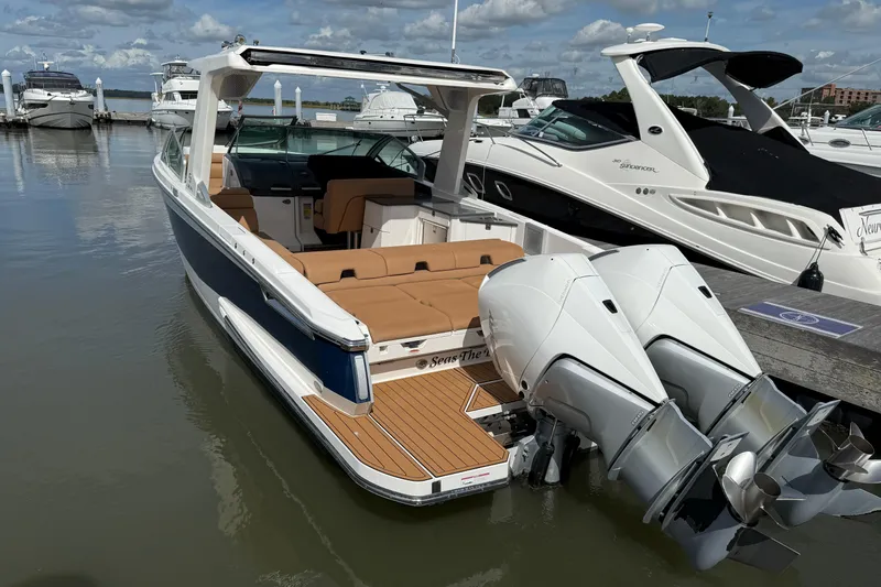 Slide: The Image of 2022 Aviara AV32 OB boat docked, featuring twin outboard engines and luxurious seating. - 2