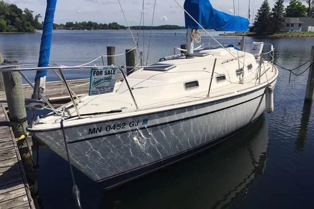 Slide: The Image of 1983 Pearson 303 sailboat docked, for sale, with blue sail cover, calm waters. - 13