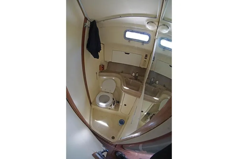 Slide: The Image of Interior of 1983 Pearson 303 sailboat bathroom with toilet, sink, and mirror. - 6