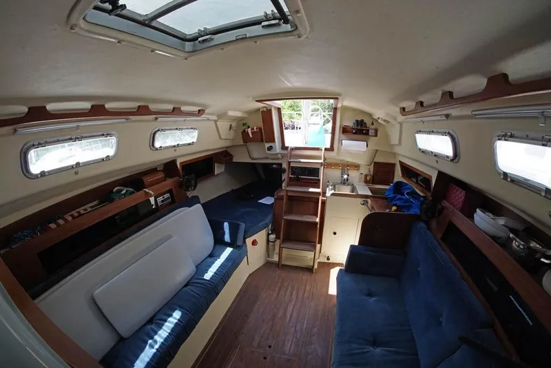 Slide: The Image of Interior of a 1983 Pearson 303 sailboat with cozy seating and wooden accents. - 8