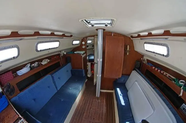 Slide: The Image of Interior of 1983 Pearson 303 sailboat with blue seating and wooden accents. - 9