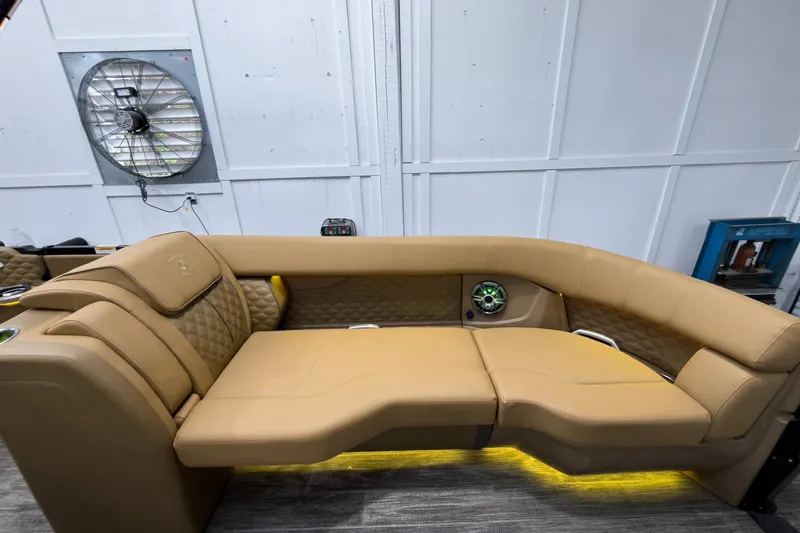 Slide: The Image of Luxurious tan seating on 2026 Godfrey Sanpan 25' Tritoon boat, featuring ambient lighting. - 16