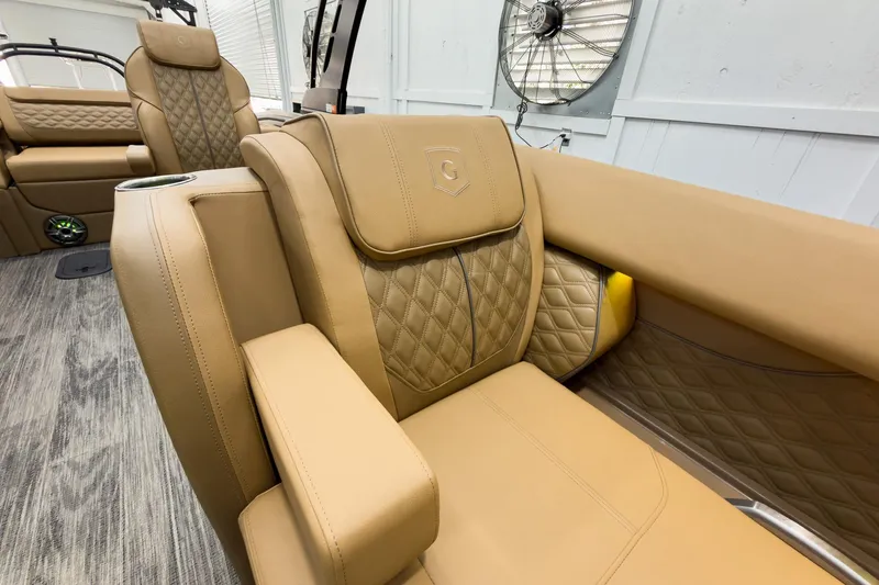 Slide: The Image of Luxurious tan seating on 2026 Godfrey Sanpan 25' Tritoon boat, featuring quilted design and armrest. - 18