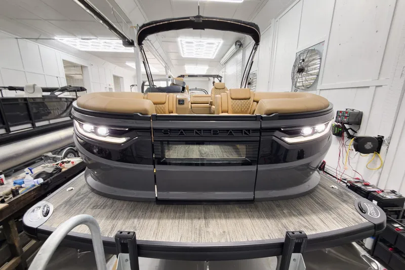 Slide: The Image of 2026 Godfrey Sanpan 25' Tritoon with luxurious seating in a showroom setting. - 3