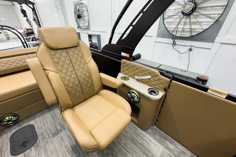 Slide: The Image of Luxurious tan seating on 2026 Godfrey Sanpan 25' Tritoon boat, featuring cup holders and speakers. - 32
