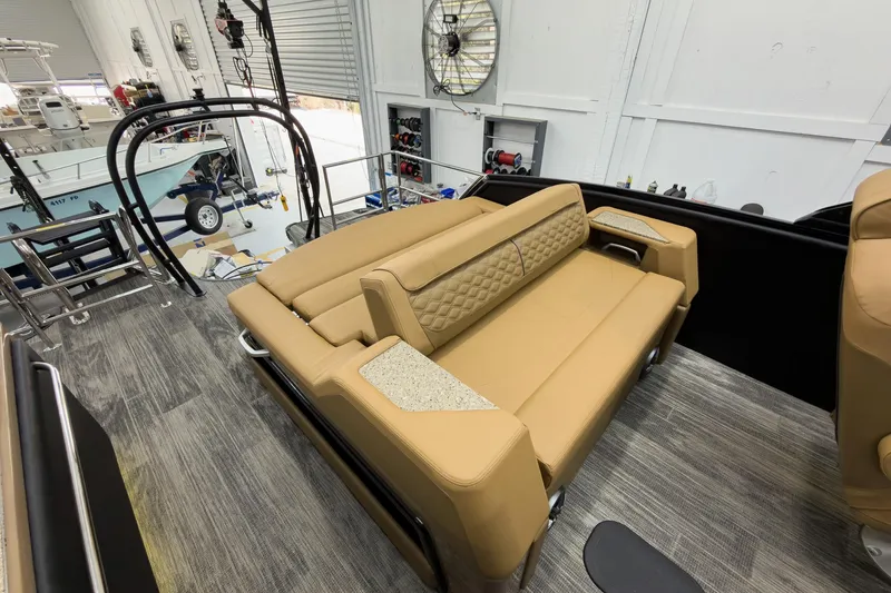 Slide: The Image of Luxurious tan seating on 2026 Godfrey Sanpan 25' Tritoon boat in a showroom. - 35