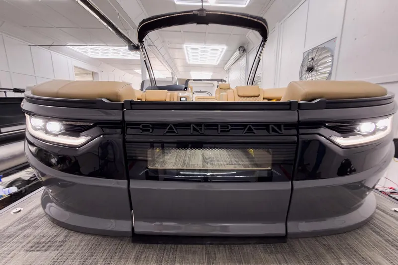 Slide: The Image of 2026 Godfrey Sanpan 25' Tritoon with flip lounge, showcased in a modern indoor setting. - 4