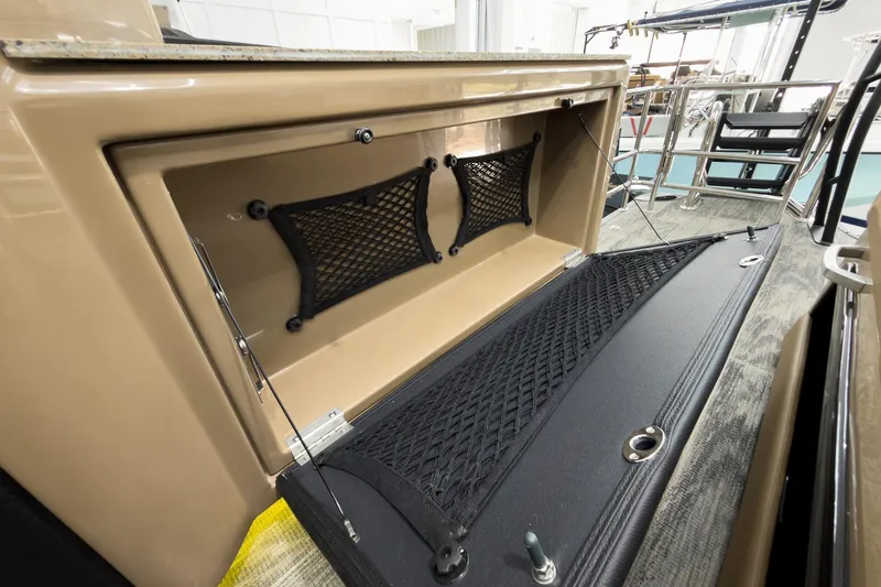 Slide: The Image of Storage compartment on 2026 Godfrey Sanpan 25' Tritoon boat with netting and secure latch. - 44