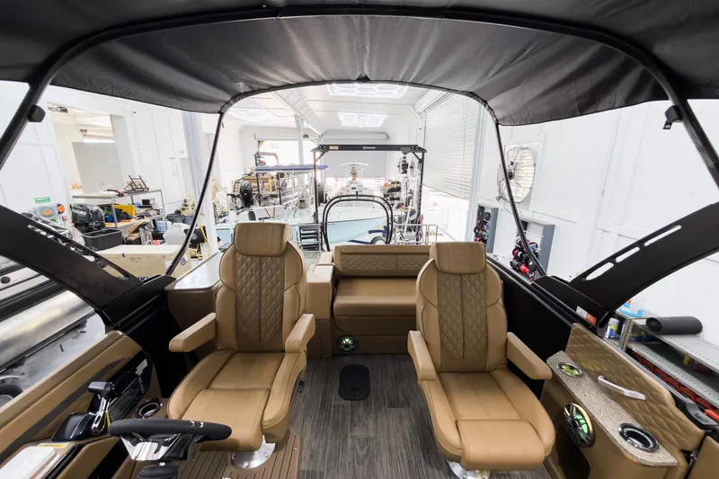 Slide: The Image of Luxurious interior of 2026 Godfrey Sanpan 25' Tritoon with tan seating and modern controls. - 56