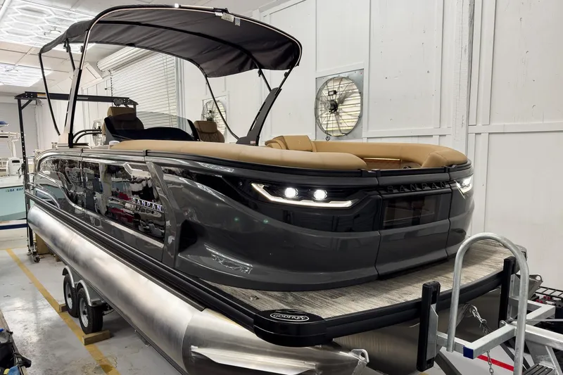 Slide: The Image of 2026 Godfrey Sanpan 25' Tritoon boat with sleek design in a showroom. - 58