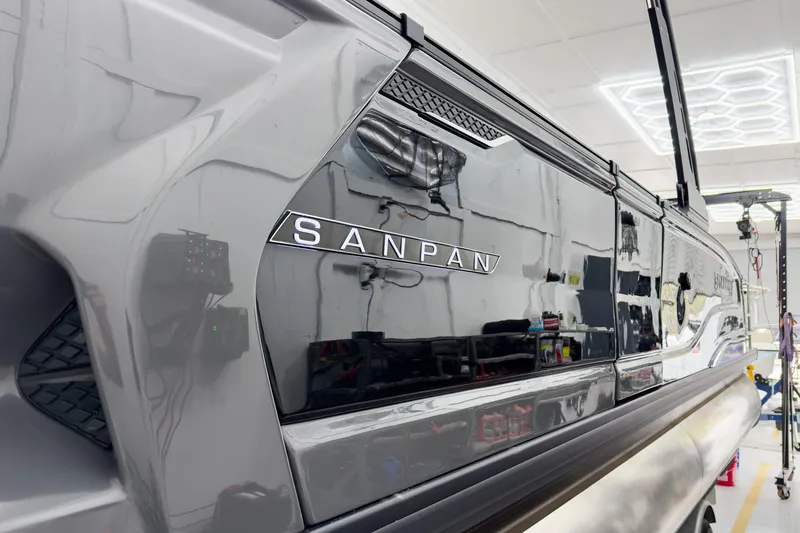 Slide: The Image of 2026 Godfrey Sanpan 25' Tritoon boat in showroom, showcasing sleek design and branding. - 6