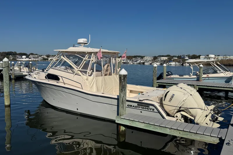 Slide: The Image of 2024 Grady-White Marlin 300 boat docked near a bridge on a sunny day. - 1