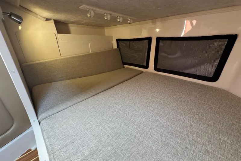 Slide: The Image of 2024 Grady-White Marlin 300 cabin interior with cushioned seating and windows. - 13