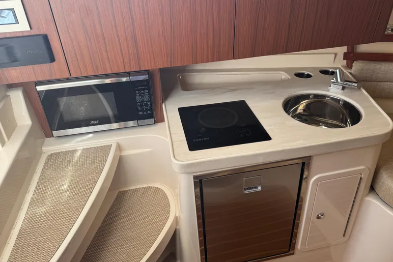 Slide: The Image of 2024 Grady-White Marlin 300 cabin interior with kitchenette and seating area. - 17