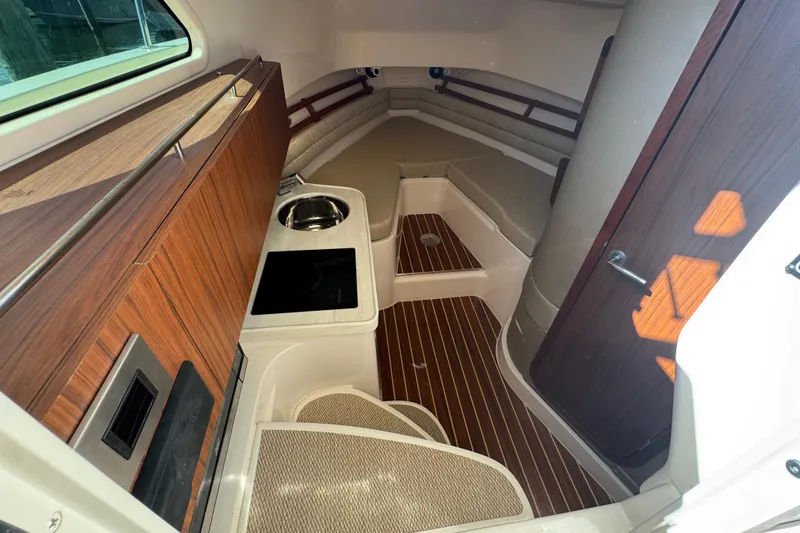 Slide: The Image of 2024 Grady-White Marlin 300 boat kitchen with microwave, sink, and compact fridge. - 18