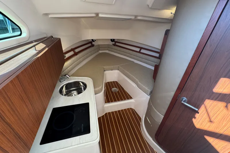 Slide: The Image of 2024 Grady-White Marlin 300 cabin interior with kitchenette and seating area. - 19