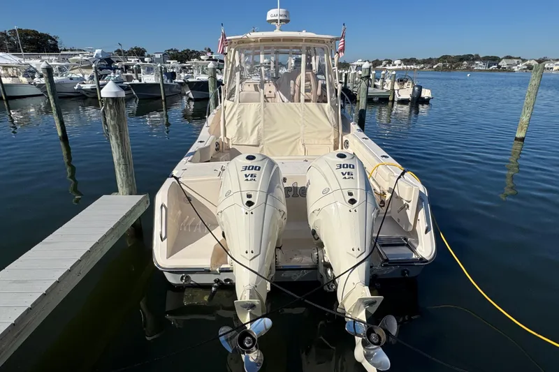 Slide: The Image of 2024 Grady-White Marlin 300 boat docked at marina under clear blue sky. - 2