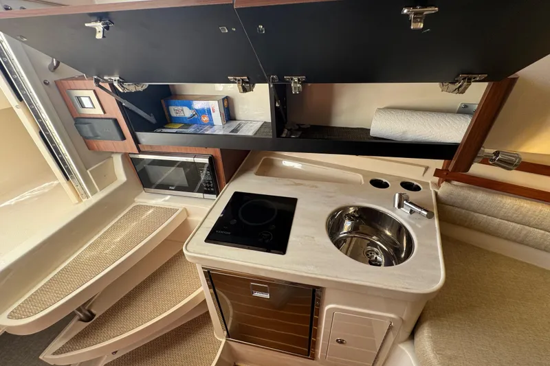 Slide: The Image of 2024 Grady-White Marlin 300 cabin interior with TV and magazine rack. - 22