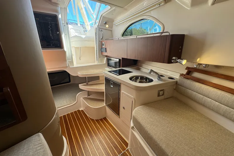 Slide: The Image of 2024 Grady-White Marlin 300 boat interior with kitchenette, sink, and storage cabinets. - 23