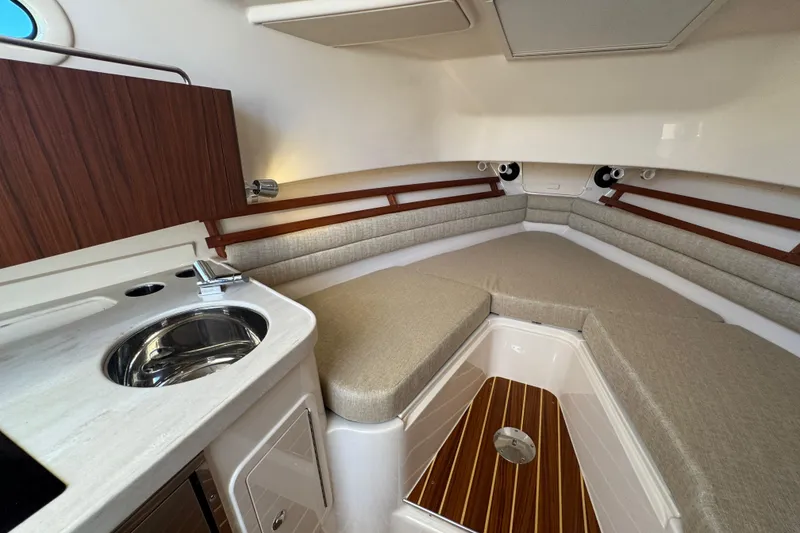 Slide: The Image of 2024 Grady-White Marlin 300 cabin interior with kitchenette, seating, and wood flooring. - 25