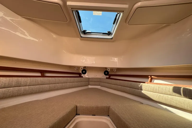 Slide: The Image of 2024 Grady-White Marlin 300 cabin interior with cushioned seating and wood accents. - 27