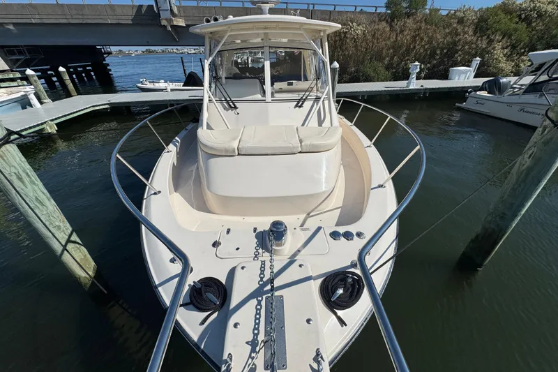 Slide: The Image of 2024 Grady-White Marlin 300 boat deck with cushioned seating, docked in marina. - 31