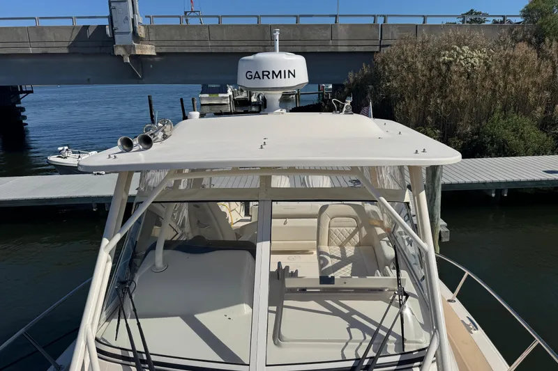 Slide: The Image of 2024 Grady-White Marlin 300 boat docked at marina, featuring sleek design and Garmin equipment. - 35