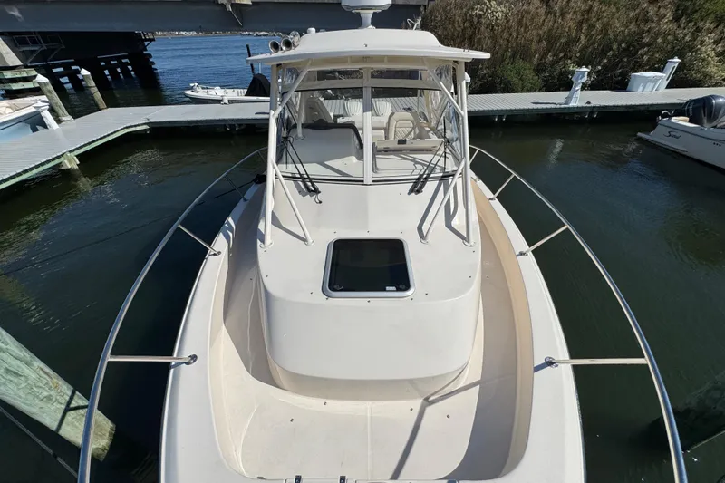 Slide: The Image of 2024 Grady-White Marlin 300 boat bow, docked in a marina, showcasing sleek design. - 37