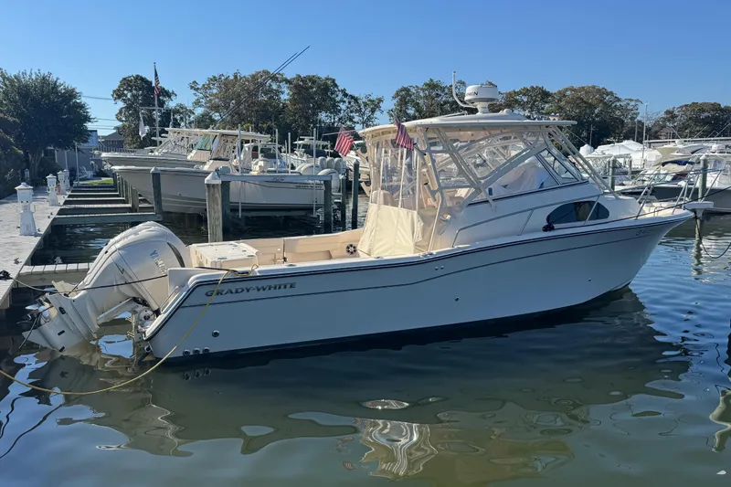 Slide: The Image of 2024 Grady-White Marlin 300 boat docked at marina under clear blue sky. - 4