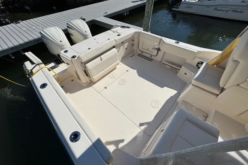 Slide: The Image of 2024 Grady-White Marlin 300 boat docked, featuring spacious deck and seating area. - 44