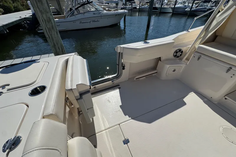 Slide: The Image of 2024 Grady-White Marlin 300 boat deck with dual engines, docked at marina. - 45