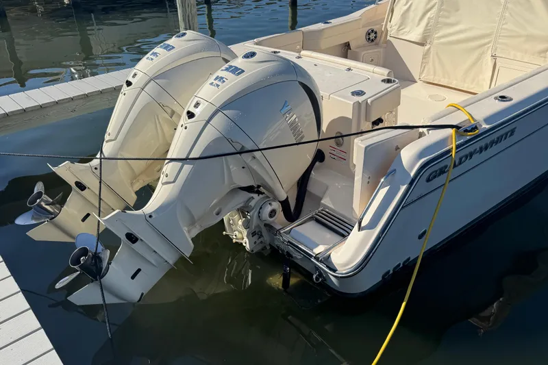 Slide: The Image of 2024 Grady-White Marlin 300 boat docked at marina, clear sky background. - 5