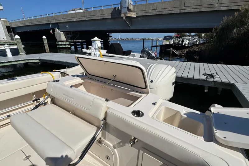 Slide: The Image of 2024 Grady-White Marlin 300 boat interior with seating and twin engines at dock. - 51