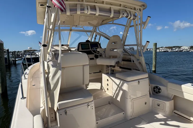Slide: The Image of 2024 Grady-White Marlin 300 boat docked, showcasing spacious deck and helm area. - 55