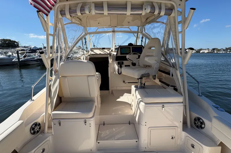 Slide: The Image of 2024 Grady-White Marlin 300 boat interior with helm, docked by the water. - 56