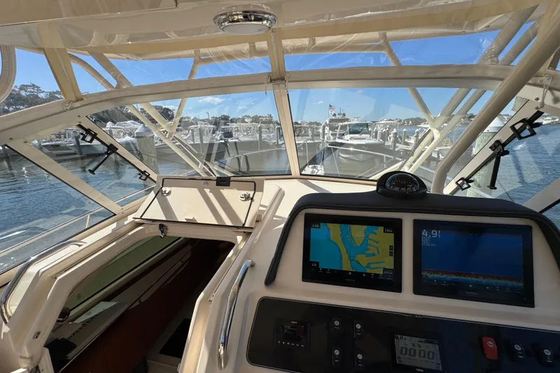 Slide: The Image of 2024 Grady-White Marlin 300 boat interior with cushioned seating at marina. - 65