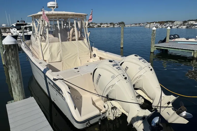 Slide: The Image of 2024 Grady-White Marlin 300 boat docked at marina, featuring enclosed cockpit. - 7