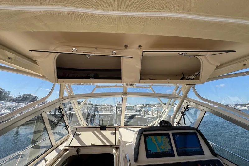 Slide: The Image of 2024 Grady-White Marlin 300 helm with navigation screens, docked at marina. - 79