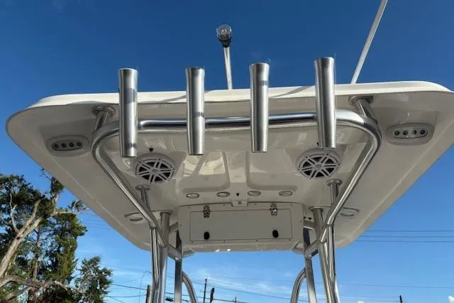 Slide: The Image of 2025 Sea Hunt Ultra 219 boat top view with rod holders and speakers against blue sky. - 15