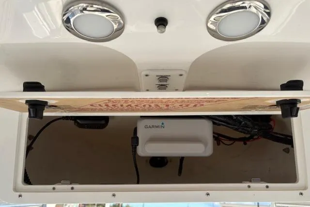 Slide: The Image of 2025 Sea Hunt Ultra 219 boat compartment with Garmin electronics and wiring. - 18