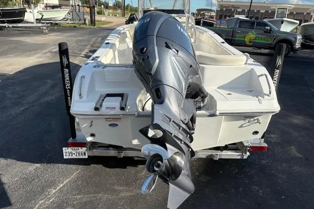 Slide: The Image of 2025 Sea Hunt Ultra 219 boat with powerful outboard motor, parked on a sunny day. - 2