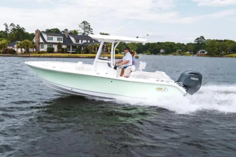 Slide: The Image of Manufacturer Provided Image: 2025 Sea Hunt Ultra 219 boat cruising on a lake near waterfront homes. - 21
