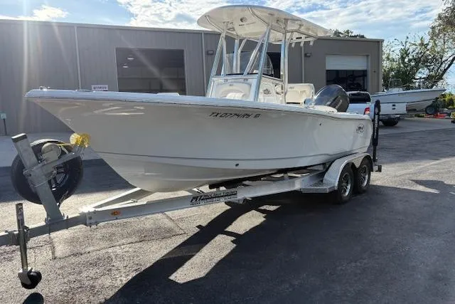 Slide: The Image of 2025 Sea Hunt Ultra 219 boat on trailer, parked outside a building. - 3