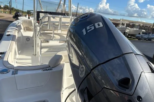 Slide: The Image of 2025 Sea Hunt Ultra 219 boat with 150 horsepower engine, docked under a clear sky. - 8