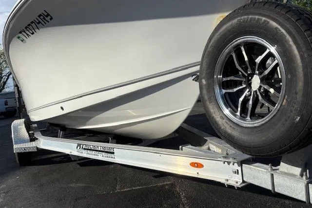 Slide: The Image of 2025 Sea Hunt Ultra 219 boat on trailer with chrome wheel, parked on asphalt. - 9