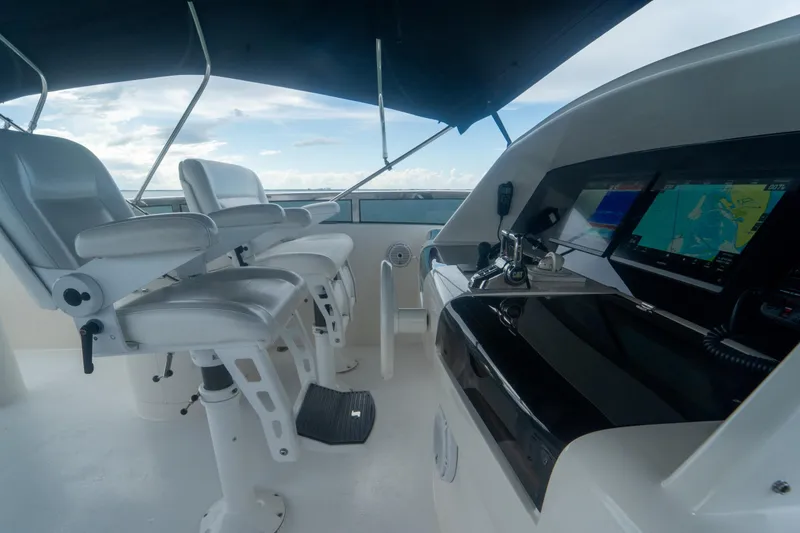 Slide: The Image of 2008 Lazzara 84 Open Bridge yacht helm with navigation screens and captain chairs. - 19