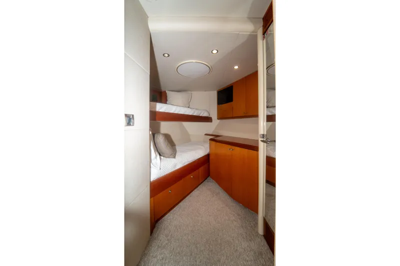 Slide: The Image of 2008 Lazzara 84 Open Bridge yacht cabin with bunk beds and wooden cabinetry. - 44