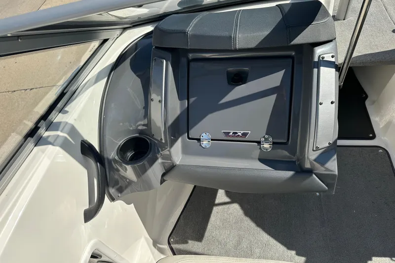 Slide: The Image of 2013 Larson LX 180S OB boat interior with storage compartment and cup holder. - 6