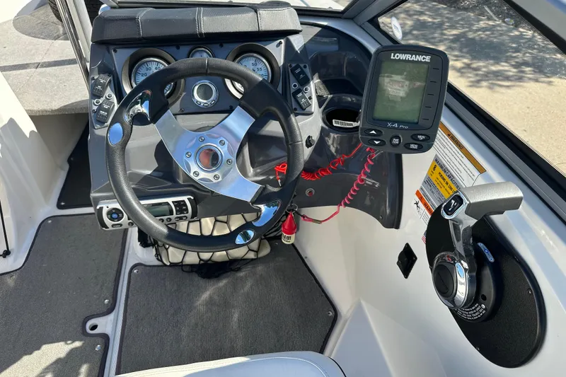 Slide: The Image of 2013 Larson LX 180S OB boat dashboard with steering wheel and Lowrance X-4 Pro fishfinder. - 7
