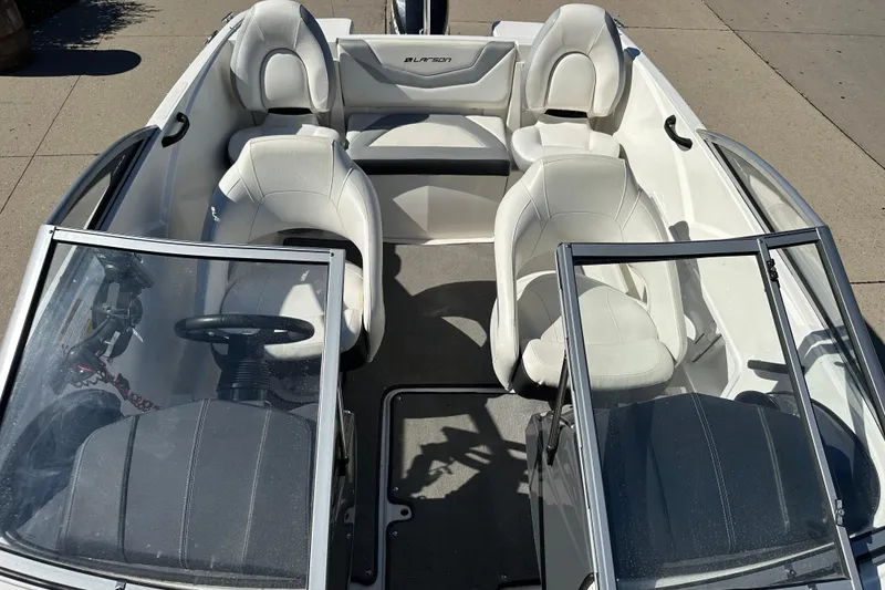 Slide: The Image of 2013 Larson LX 180S OB boat interior with white seating and dual consoles. - 8